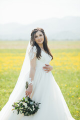 Fototapeta na wymiar portrait of beautiful bride with wedding bouquet isolated at green natural summer field background.