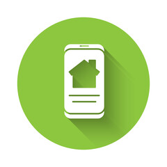 White Online real estate house on smartphone icon isolated with long shadow. Home loan concept, rent, buy, buying a property. Green circle button. Vector Illustration.