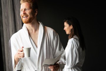 Male in bathrobe relaxing while drinking tea