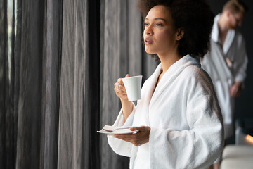 Woman in bathrobes enjoying tea during wellness weekend