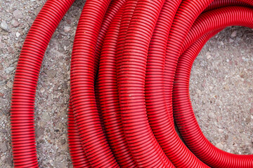 Red plastic tubing for underground cable protection on the street
