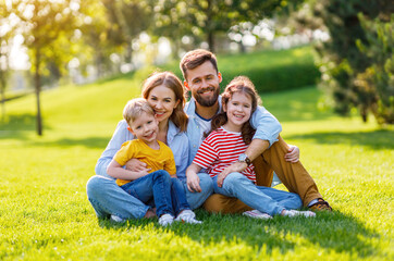 Fototapeta premium Delighted family hugging on lawn.