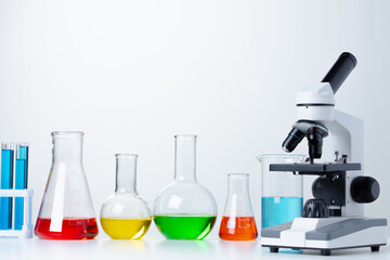 Lab microscope with laboratory glassware on desk