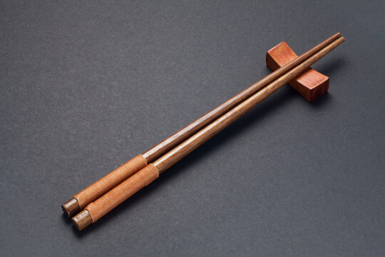 Wooden chopsticks on black paper background