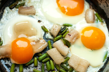 scrambled eggs with lard on a frying pan