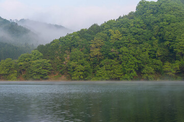 靄の発生した山々と湖