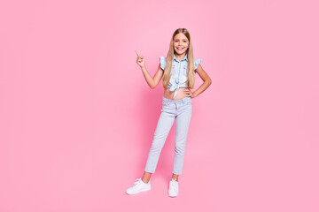 Full length photo positive cheerful kid girl promoter point index finger copyspace present adverts promotion recommend suggest select wear trendy clothes isolated pastel color background