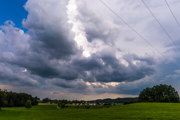 Fototapeta premium gloomy thunderclouds over a rural area with meadows and forest in the Baden Allgäu near Wolfegg