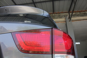 Close-up detail body part of grey car parking in the home. Photo of grey car in low light.
