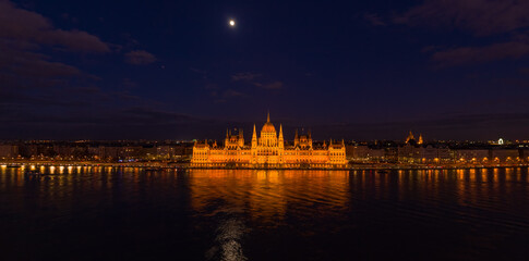 Fototapeta na wymiar Panoramic aerial drone shot of Hungarian Parliament with lights on during Budapest evening