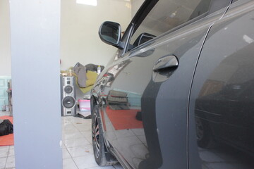 Fototapeta premium Close-up detail body part of grey car parking in the home. Photo of grey car in low light.