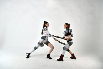 Fototapeta na wymiar beautiful girls in costumes of robots quarreled and fight with a battle ax and a war hammer