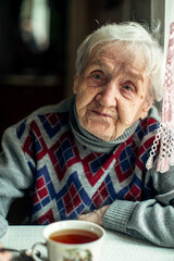 Portrait of an elderly woman drinking tea.