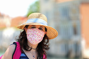 cute young woman with straw hat and big surgical mask to protect