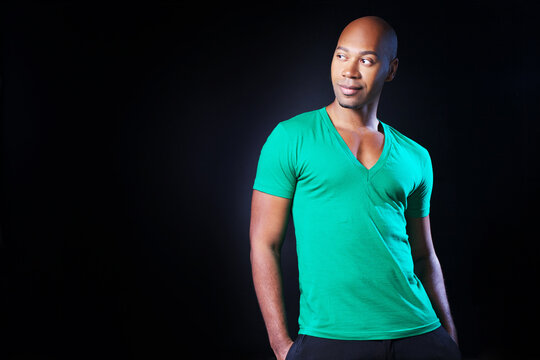 African american bald man in green t-shirt isolated on black background