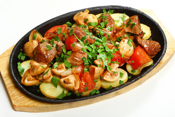 Sizzling skillet. Fried pork with vegetables.