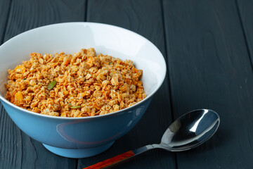 Bowl with granola on wooden table close up