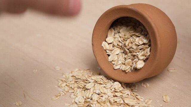 Rolled oats grains in a faience pot. 4k video shot.