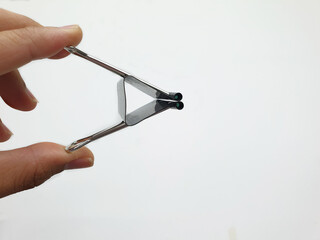 Finger holding the paper clip, white background