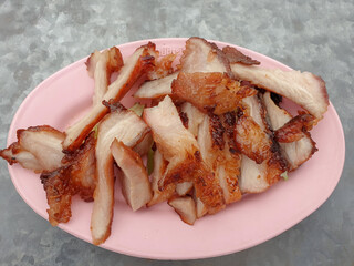 Pork neck grilled in a pink dish, cut into pieces, Lard meat stick ,close up,