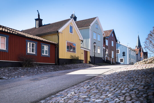 2020: Street with typical Swedish colored houses with the Sankt Petri Kyrka or Saint Peter Church on the right in V&auml;stervik (Vastervik) in Sweden