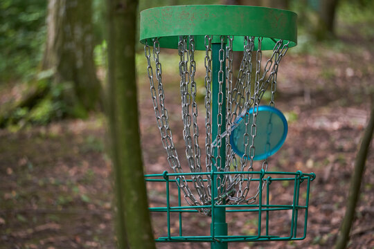 Blue Disc golf disc in the chain of basket