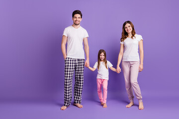 Fototapeta premium Full length body size view of nice lovely cheerful careful family mommy daddy daughter holding hands sleepwear bedtime isolated on bright vivid shine vibrant violet color background
