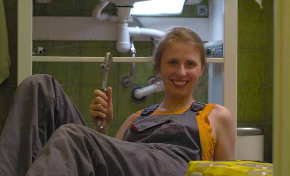 Happy woman with the wrench in her hands
