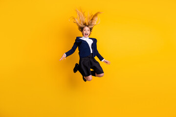Fototapeta na wymiar Full length body size profile side view small little cheerful schoolchild jumping having fun fooling after classes free time vacation rest isolated bright vivid shine vibrant yellow color background