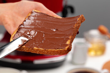 Female hand cooking toast with chocolate paste