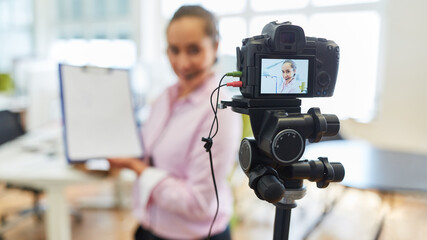 Young businesswoman in front of the video camera for a tutorial