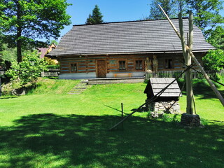 Old well on the background of an old wooden house.