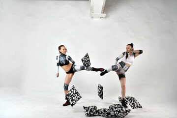 beautiful girls in suits of robots as children play with pillows and throw them