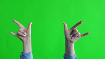 Sign of the horns with fingers on green screen. Simbol of heavy metal rock. Gestures with fingers of one hand.