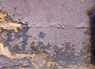 old weathered wall with peeling paint in different gray and yellow layers - rough dirty texture for a background surface