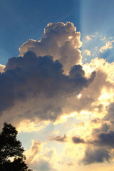 Colorful vibrant sky. Light from heaven. Picturesque view of sky with clouds. They are backlit by the sun. Blue sky background with clouds. Beautiful sky with cloud before sunset. Abstract background