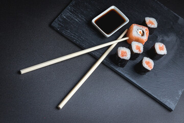 Set of traditional japanese food on a dark background. Sushi rolls. Asian food frame. Dinner party. 