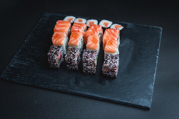 Set of traditional japanese food on a dark background. Sushi rolls. Asian food frame. Dinner party. 