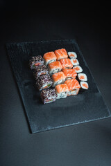 Set of traditional japanese food on a dark background. Sushi rolls. Asian food frame. Dinner party. 