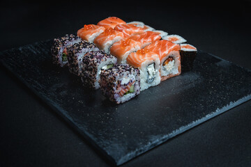 Set of traditional japanese food on a dark background. Sushi rolls. Asian food frame. Dinner party. 