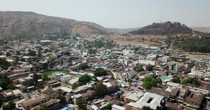 Flying over the beautiful town of Trimbak by the mountains in Maharashtra, India - aerial