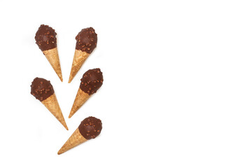 Conos de helado de chocolate sobre un fondo blanco liso y aislado. Vista superior. Copy space