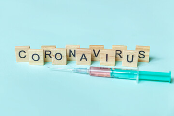 Text phrase Coronavirus and syringe on blue pastel background. Novel coronavirus 2019-nCoV MERS-Cov covid-19 middle East respiratory syndrome coronavirus virus vaccine concept.