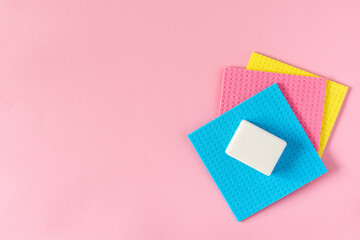 Multi-colored cloths and soap on pink background
