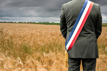 un maire face à un champ de culture