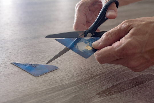 male hands with scissors cut the payment blue master card. concept of liquidation, destruction of deactivation, decommissioning