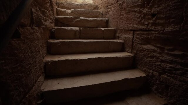 Dark ancient stairs leading to sun light from scary underground.