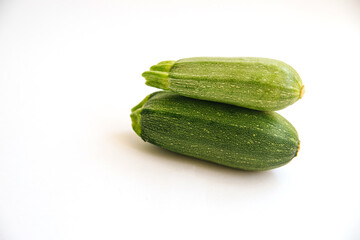 Green zucchini on a white background. The harvest of zucchini. Vegetarian food.