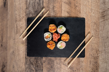 Obraz na płótnie Canvas Sushi roll set on the black plate. Japanese food.