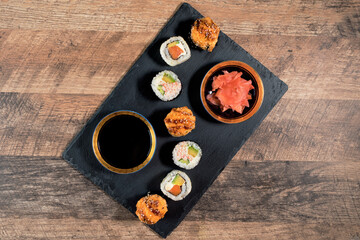 Obraz na płótnie Canvas Sushi roll set on the black plate. Japanese food.
